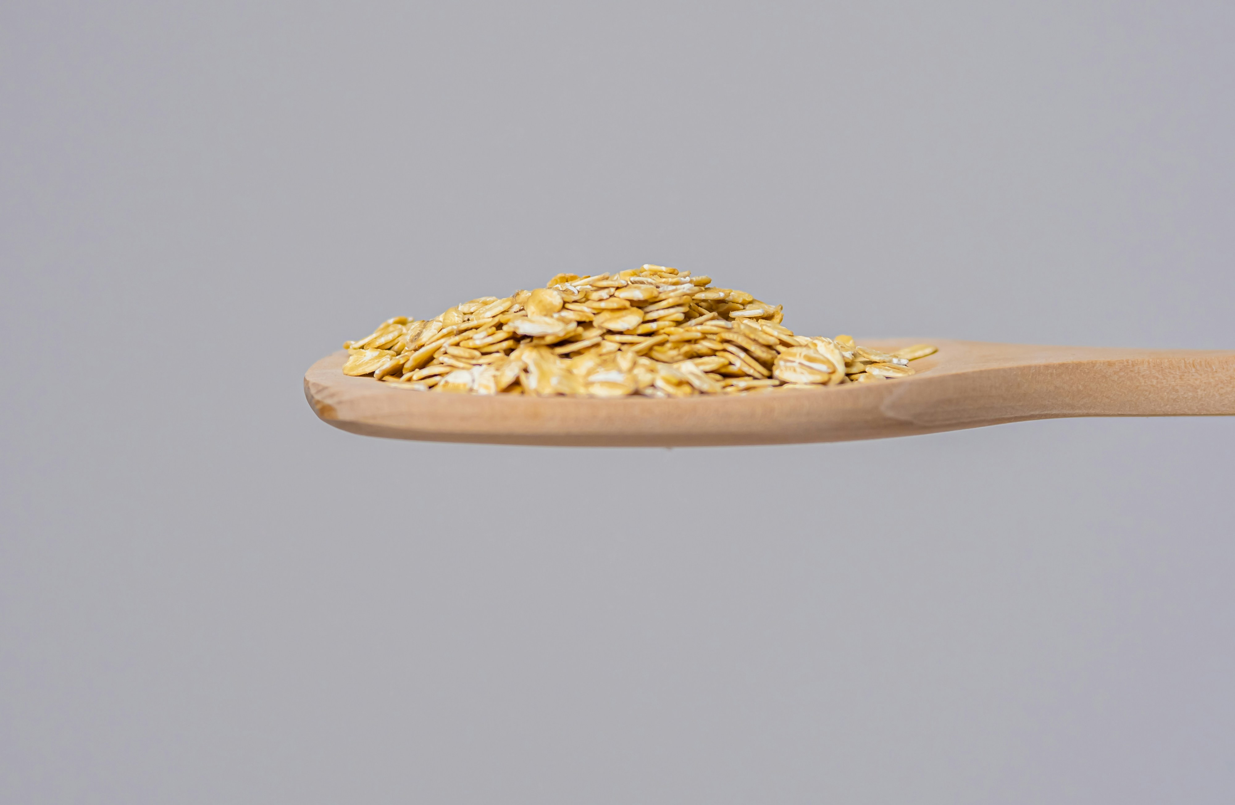 A wooden spoon full of oats